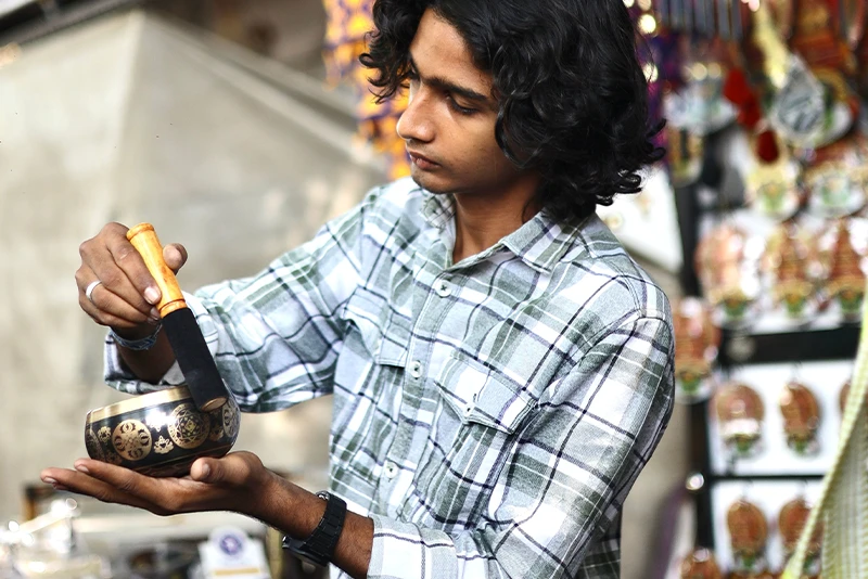 A stallholder demonstrating a singing bowl at a craft market